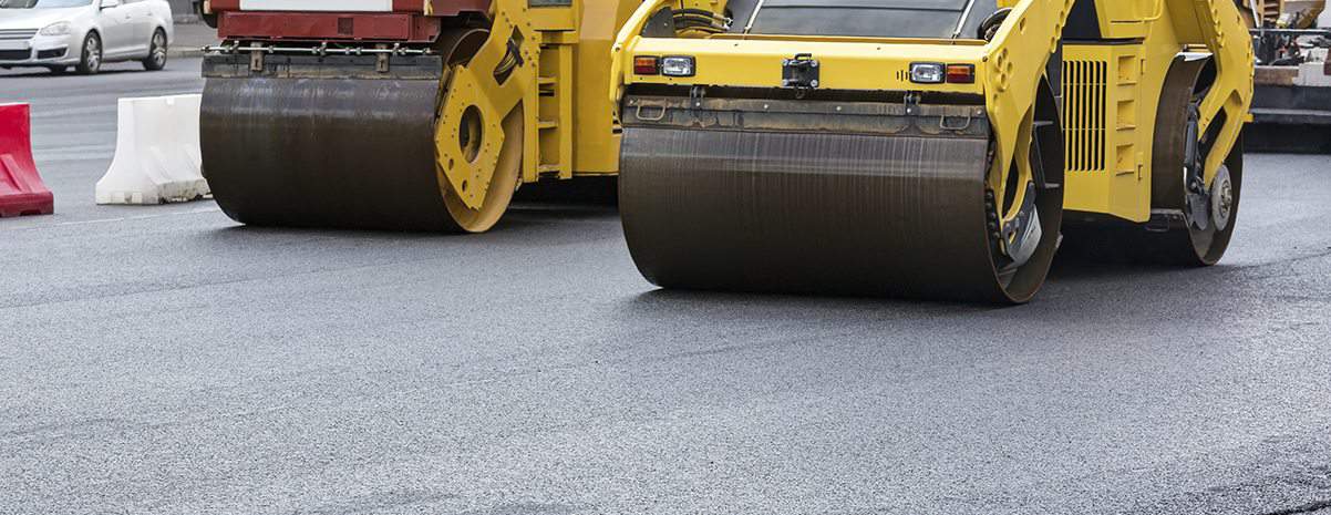 Two paving vehicles driving side by side