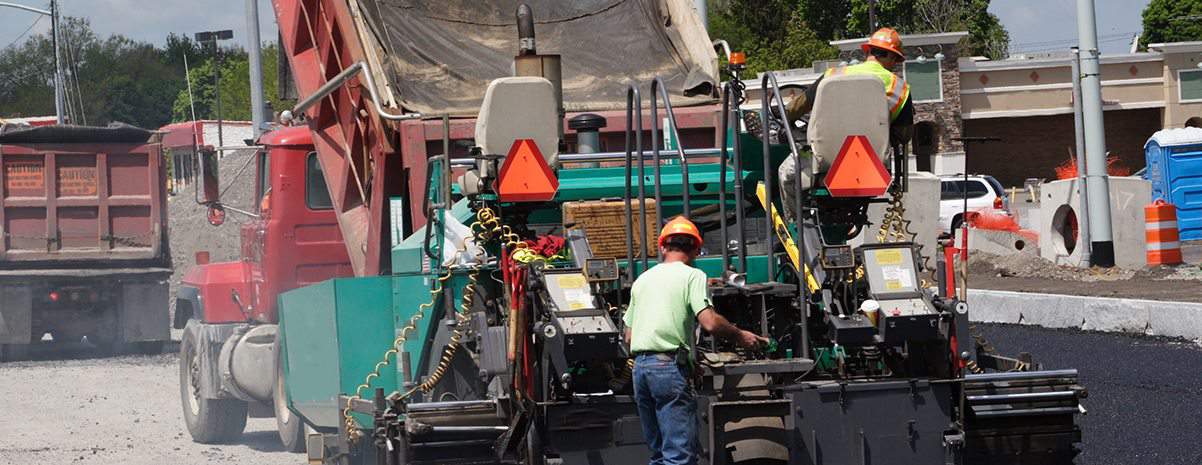 Pavers laying down asphalt on a road